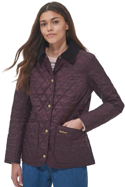 Front view of dark plum quilted jacket with gold buttons, stand collar, and front pocket