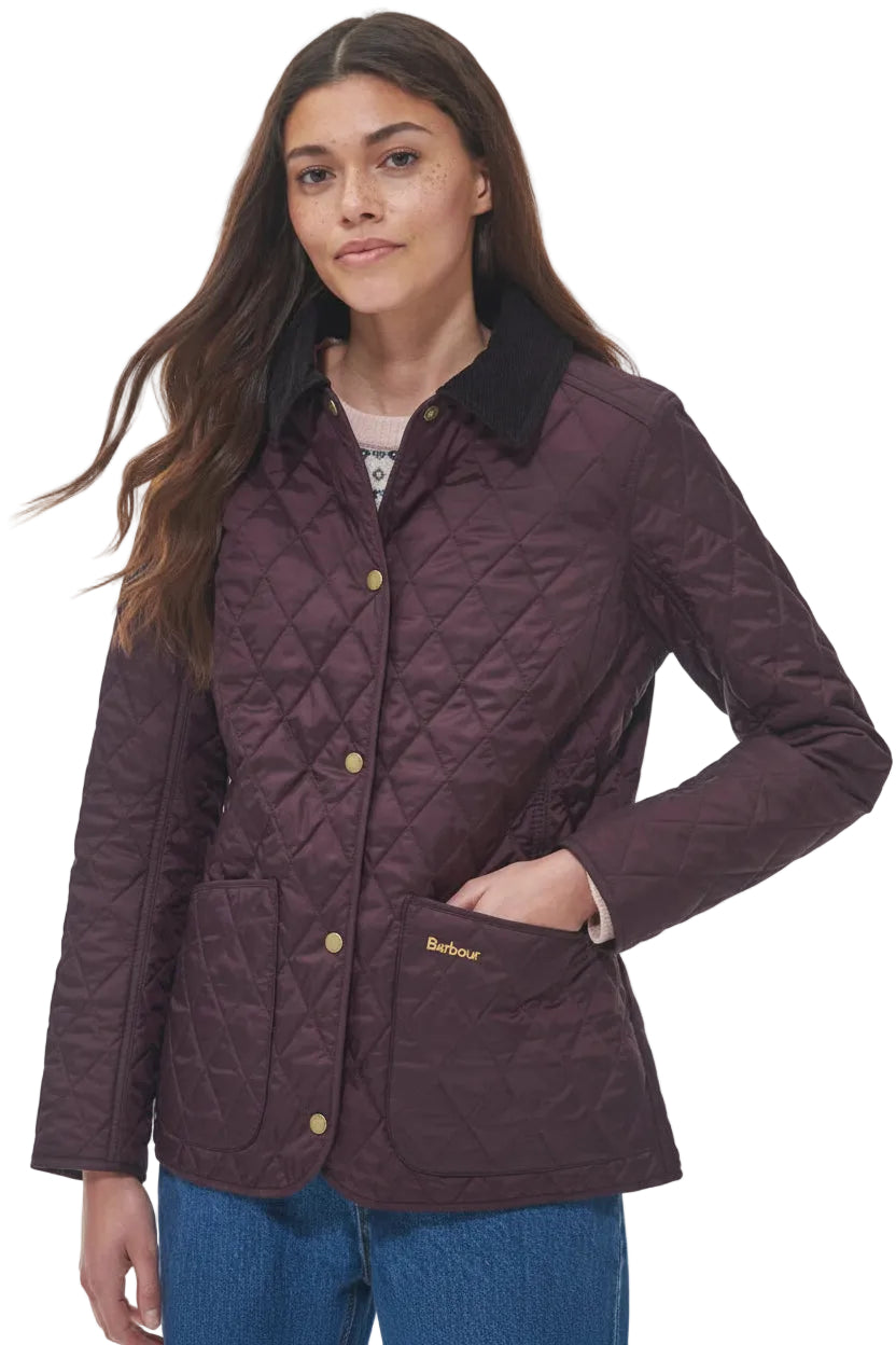 Front view of dark plum quilted jacket with gold buttons, stand collar, and front pocket