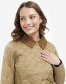 Women’s quilted tan jacket with diamond stitching and brown button-up collar detail.