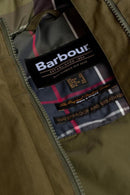 Olive waterproof jacket inner label with Barbour branding and plaid lining detail