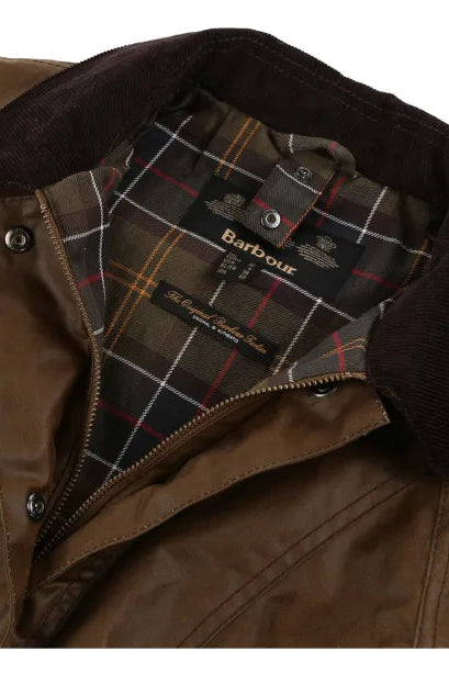 Brown jacket with plaid tartan lining panel and Barbour label near zip opening