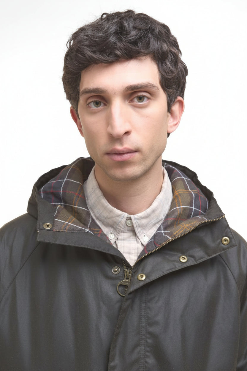 Dark olive wax parka collar with hood and tan-and-brown plaid inner lining.