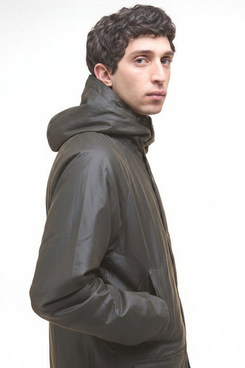 Dark olive wax parka jacket side view with high collar and stitched shoulder.