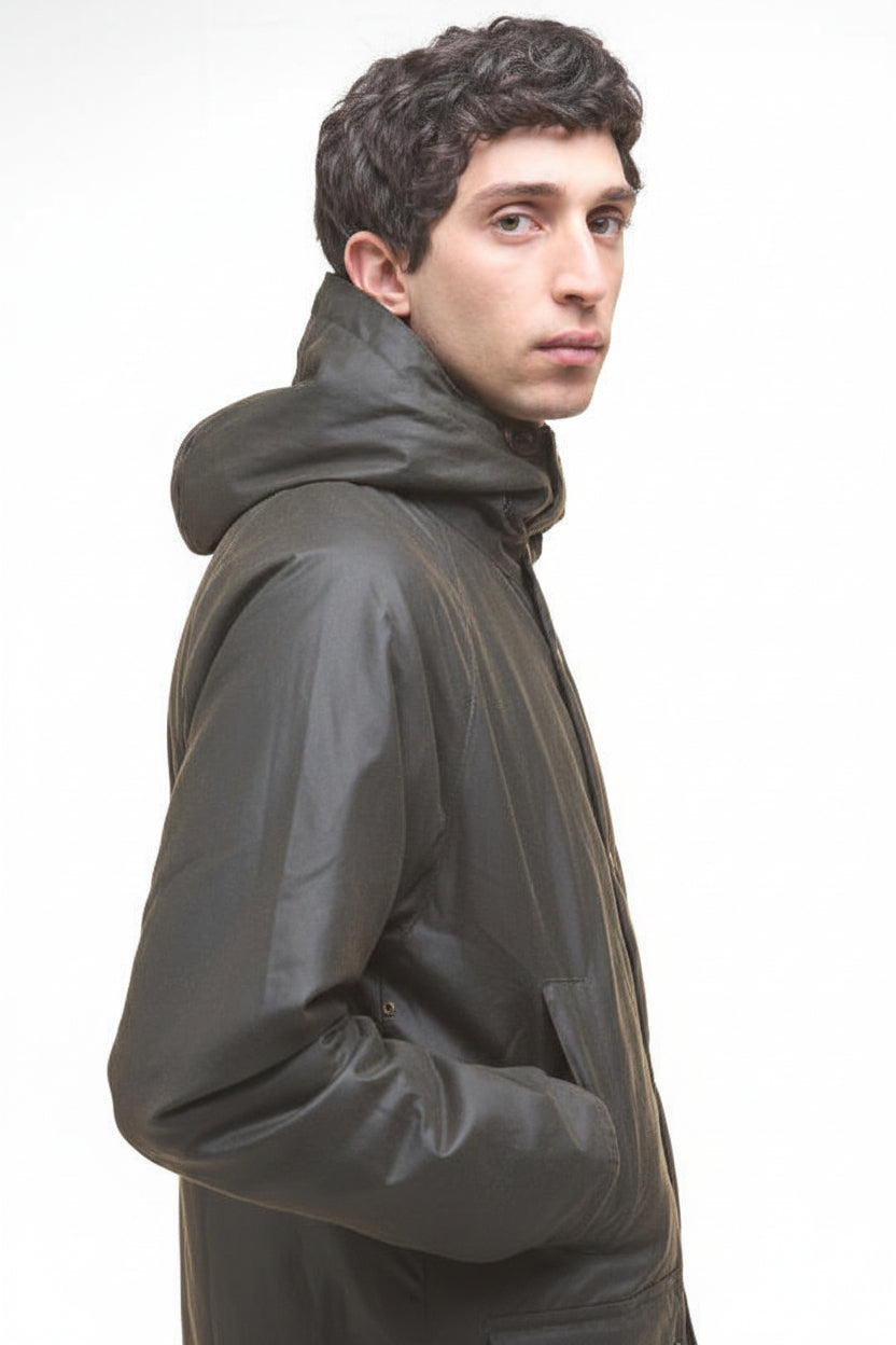 Dark olive wax parka jacket side view with high collar and stitched shoulder.