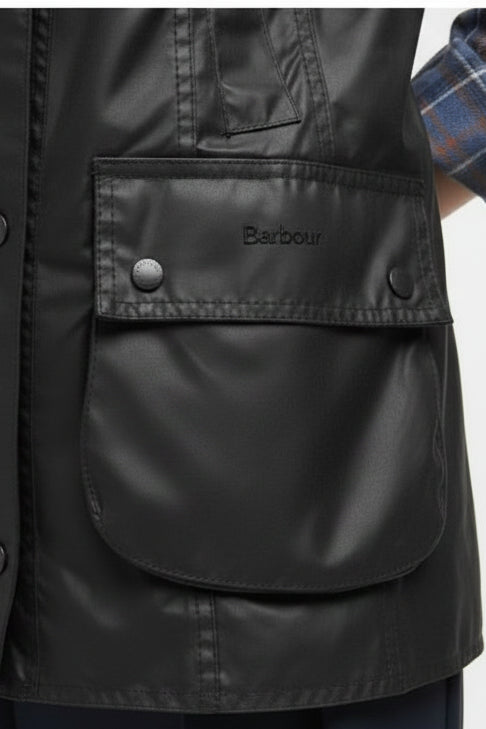 Black jacket pocket flap with Barbour logo and snap button detail