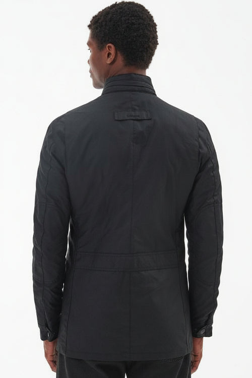 Men's black wax jacket, back view, with stand collar and horizontal seam bands.