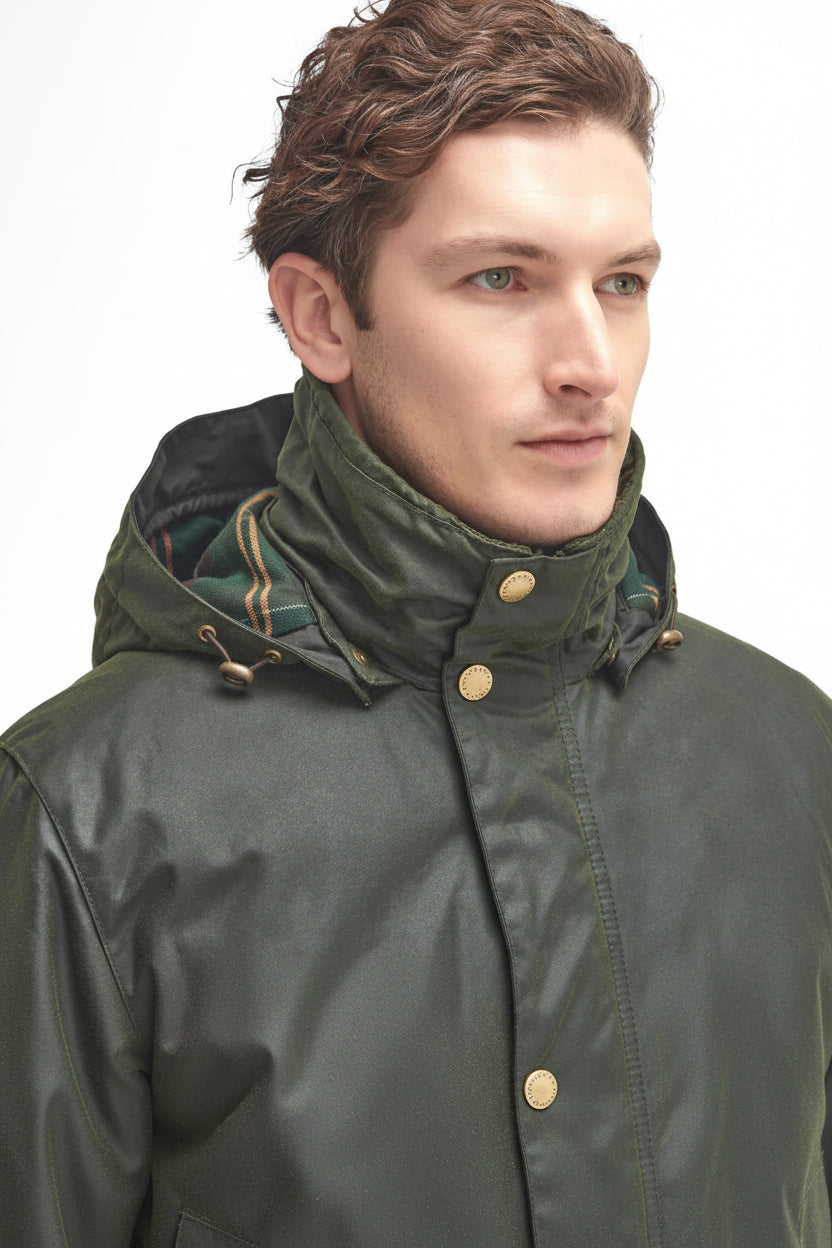 Men's dark green waxed jacket with hood and brass-tone buttons at the collar and placket.