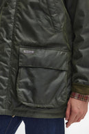 Dark green waxed jacket with Barbour patch on the chest pocket and snap button details.