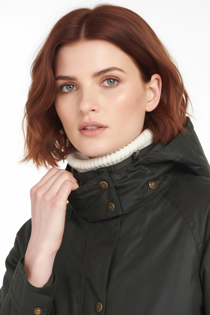 Close-up of hooded wax jacket collar with snap buttons and cream knit turtleneck lining.