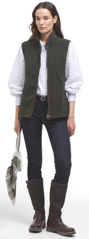 Sage green fleece gilet worn with dark jeans and brown boots; full front zip.