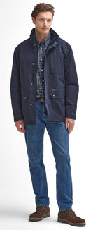 Men's navy waterproof jacket worn over a plaid shirt with blue jeans.