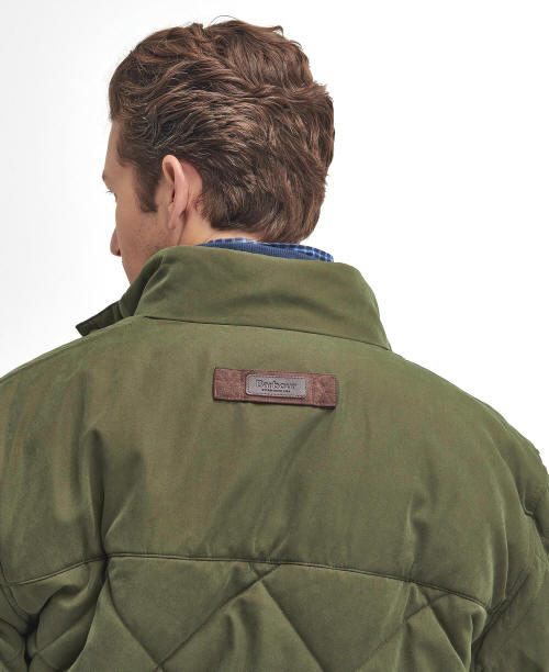 Olive quilted jacket back with stand collar and leather brand patch at shoulder.