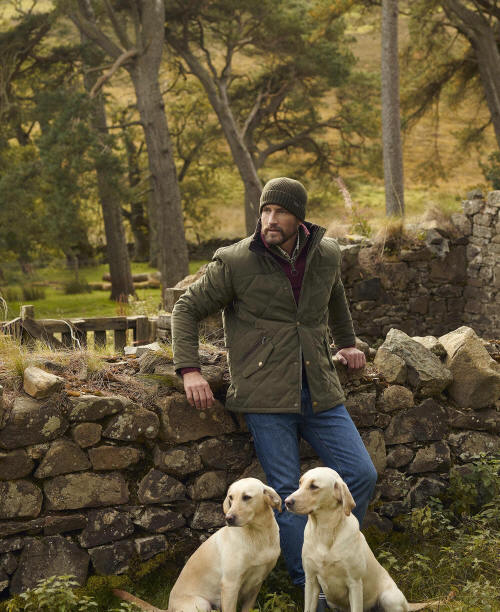 Olive quilted jacket with full button front and diamond quilting, worn outdoors.
