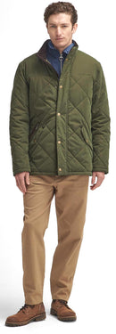 Olive quilted jacket with button closure, stand collar, and diamond quilting, with chinos.
