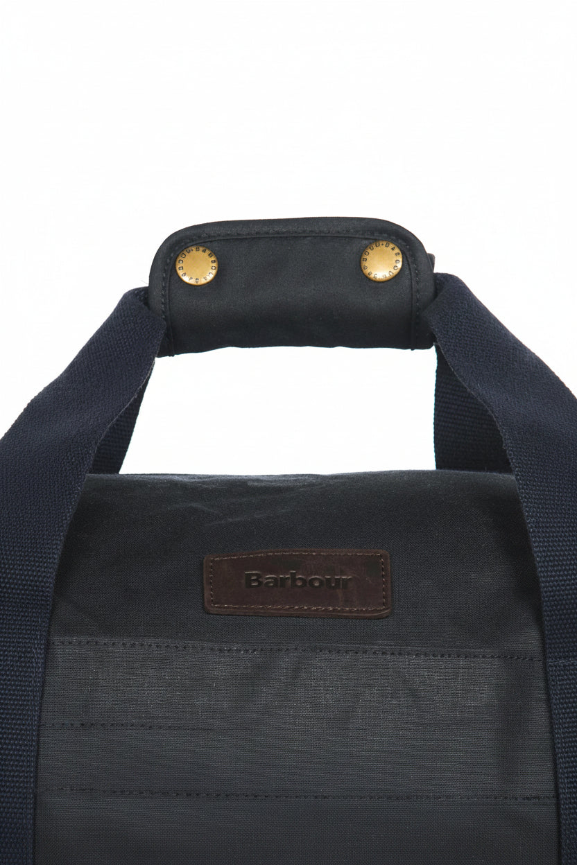 Dark navy duffle bag front with leather Barbour patch and top handle eyelets