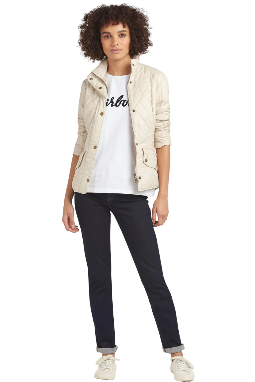 Women’s light-cream quilted jacket with stand collar and snap front, worn with dark jeans