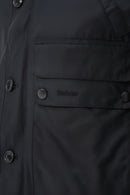 Barbour wax parka chest pocket and snap buttons with small logo patch on dark fabric