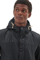 Men's black Barbour wax parka with hood drawstrings and button placket