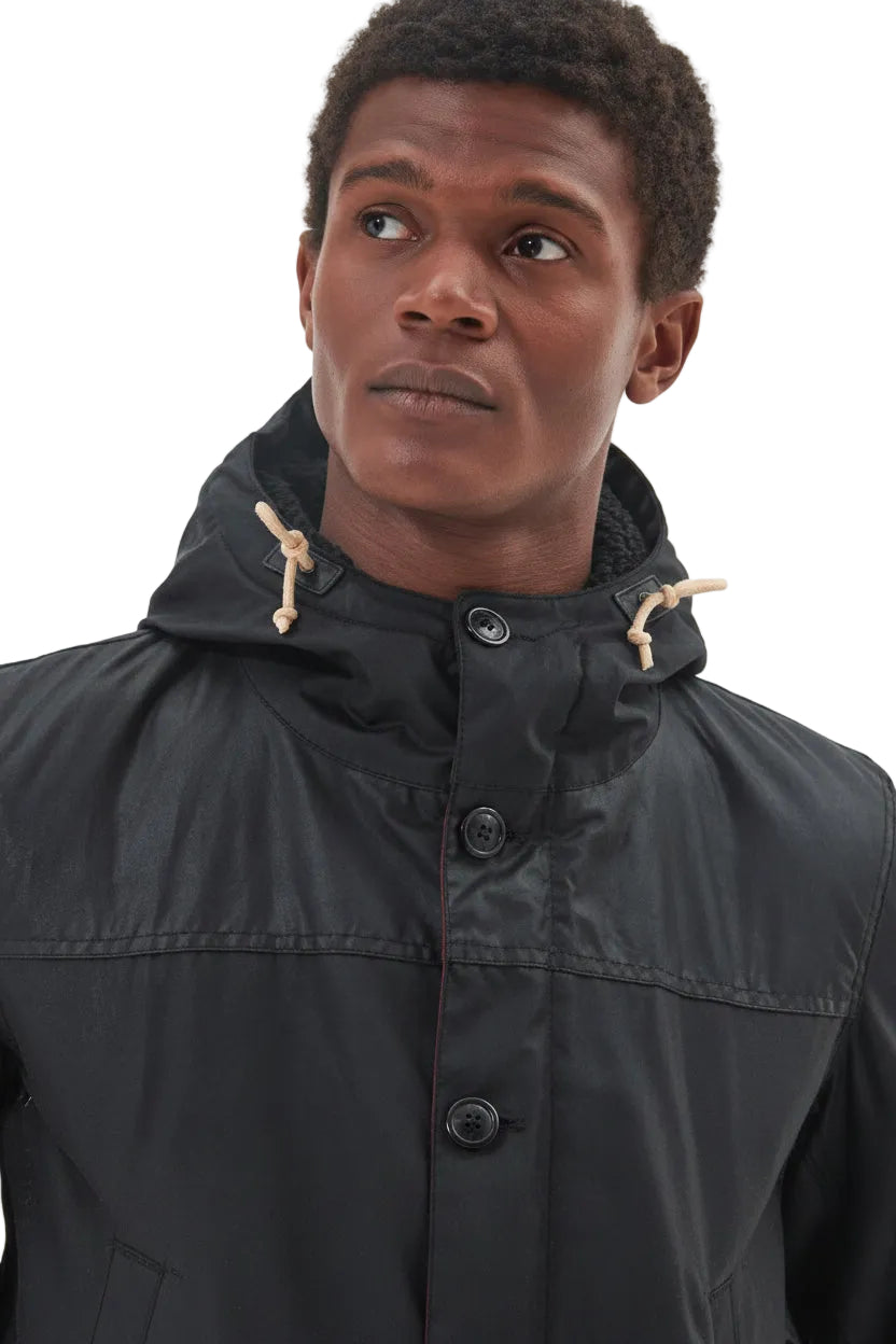 Men's black Barbour wax parka with hood drawstrings and button placket