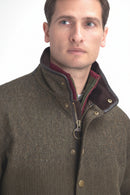 Olive tweed wool jacket with stand collar, brass buttons, and burgundy zip placket