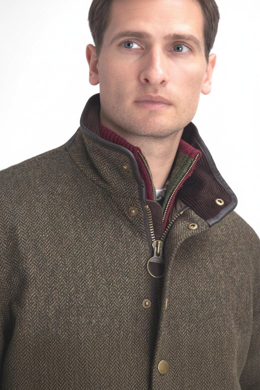 Olive tweed wool jacket with stand collar, brass buttons, and burgundy zip placket
