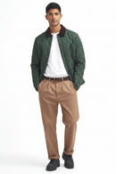 Quilted racing green jacket worn open over white tee with maroon-brown collar