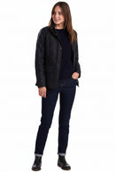 Black quilted jacket with button front, stand collar, and side pockets on model
