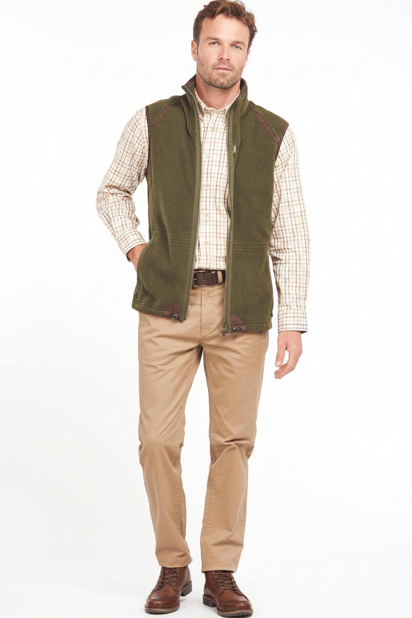 Olive fleece waistcoat worn over check shirt; zip front and stand collar.