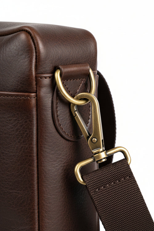 Barbour leather briefcase hardware close-up with brass D-ring and adjustable webbing strap