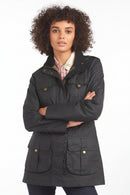 Barbour dark lightweight jacket with high stand collar and buttoned front pockets, standing pose