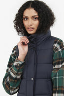 Navy quilted hooded gilet with button front, worn over plaid sleeves