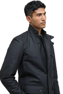Men's black wax jacket close-up with stand collar, button placket, and flap pocket
