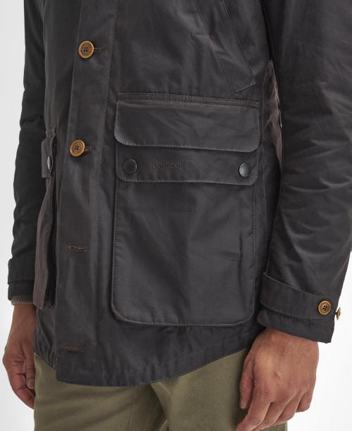 Men's dark wax parka with flap pocket and snap buttons at the front.
