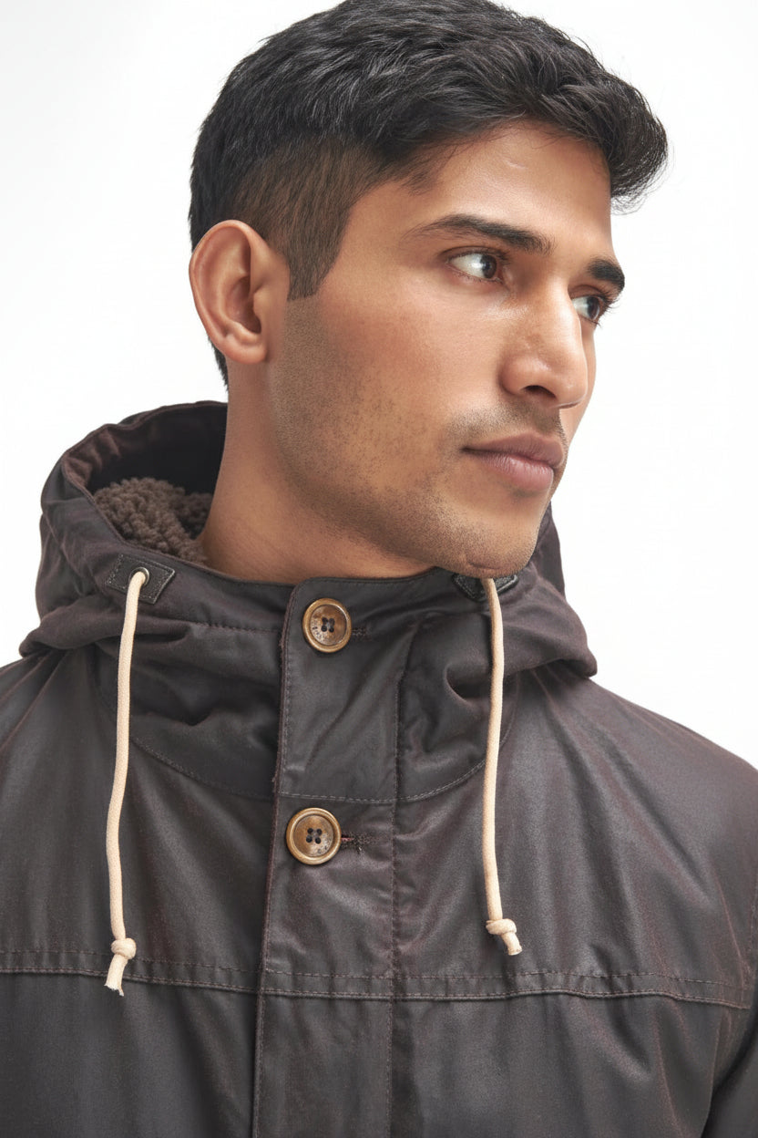 Men's dark wax parka with cord hood drawstrings and two round snap buttons.