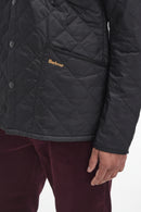 Men's black quilted jacket with snap buttons and Barbour logo on chest pocket
