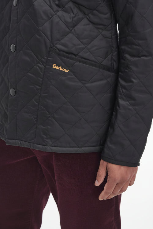 Men's black quilted jacket with snap buttons and Barbour logo on chest pocket
