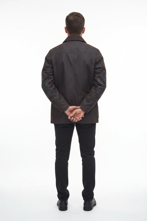 Men's Barbour wax jacket in dark brown, back view with center seam and snap cuffs.