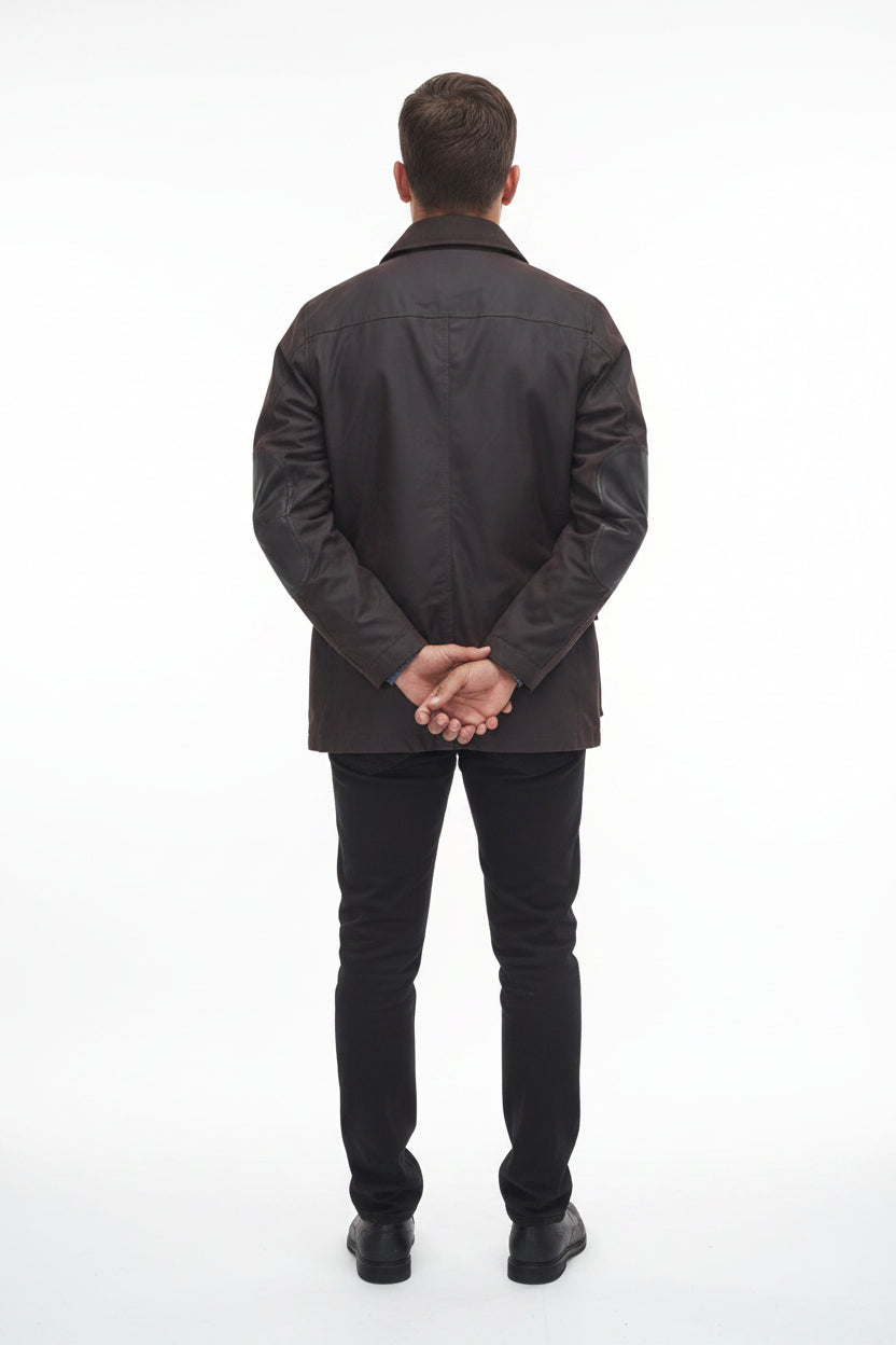 Men's Barbour wax jacket in dark brown, back view with center seam and snap cuffs.