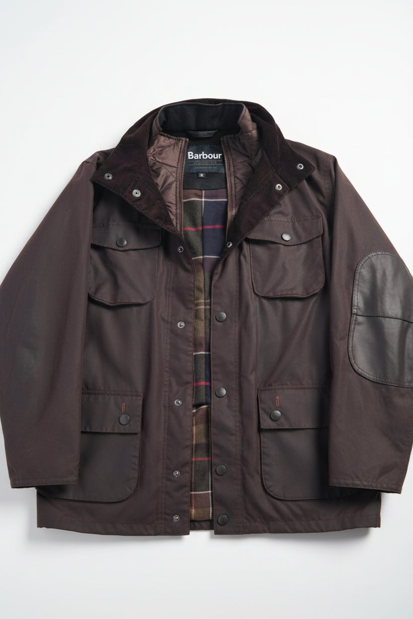 Men's Barbour wax jacket in dark brown with snap front, flap pockets, stand collar.