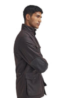 Men's Barbour wax jacket in dark brown with diagonal side strap and large flap pockets.