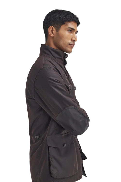 Men's Barbour wax jacket in dark brown with diagonal side strap and large flap pockets.