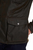 Close-up: dark olive wax jacket utility pocket on sleeve with snap detail