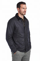 Men's navy waxcotton jacket, three-quarter view, button placket and chest pockets.