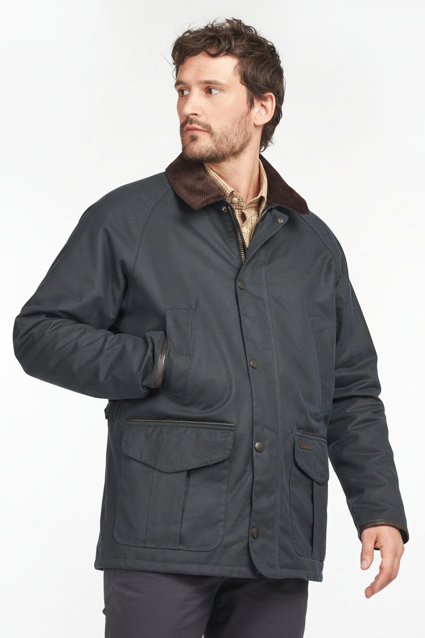 Men’s navy wax cotton jacket front pocket with snap buttons and brown trim badge