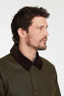 Olive wax cotton jacket worn by model, side view with dark collar