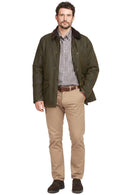 Olive wax cotton jacket with dark collar over check shirt and tan pants