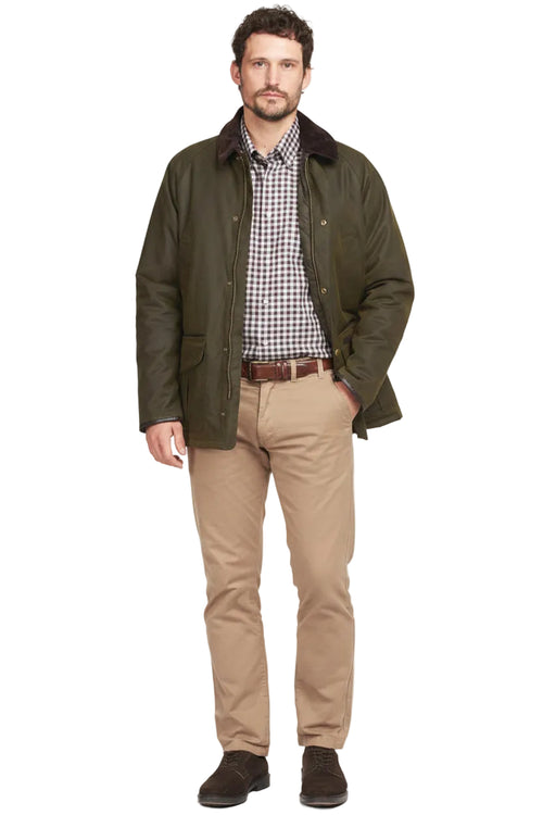 Olive wax cotton jacket with dark collar over check shirt and tan pants