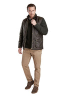 Men's waxed waistcoat with stand collar and snap front, layered over a knit sweater, multiple pockets