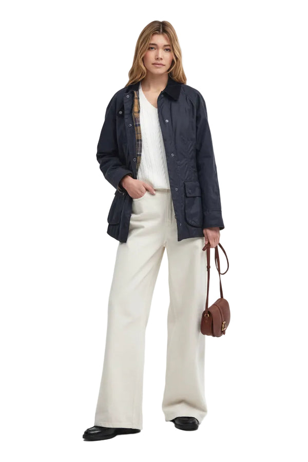 Navy wax jacket worn open with cord collar and plaid lining at cuffs
