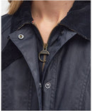 Navy wax jacket close-up with zip placket, snap throat button, and Barbour label